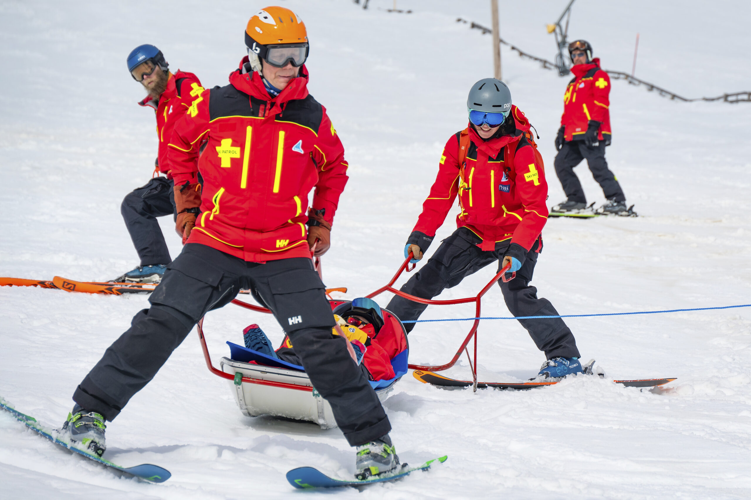Ski Patrol -partio kuljettamassa loukkaantunutta ahkiolla rinteessä